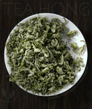 Fine silvery hairs cover he beautifully rolled tiny leaves of the green tea Biluochun.